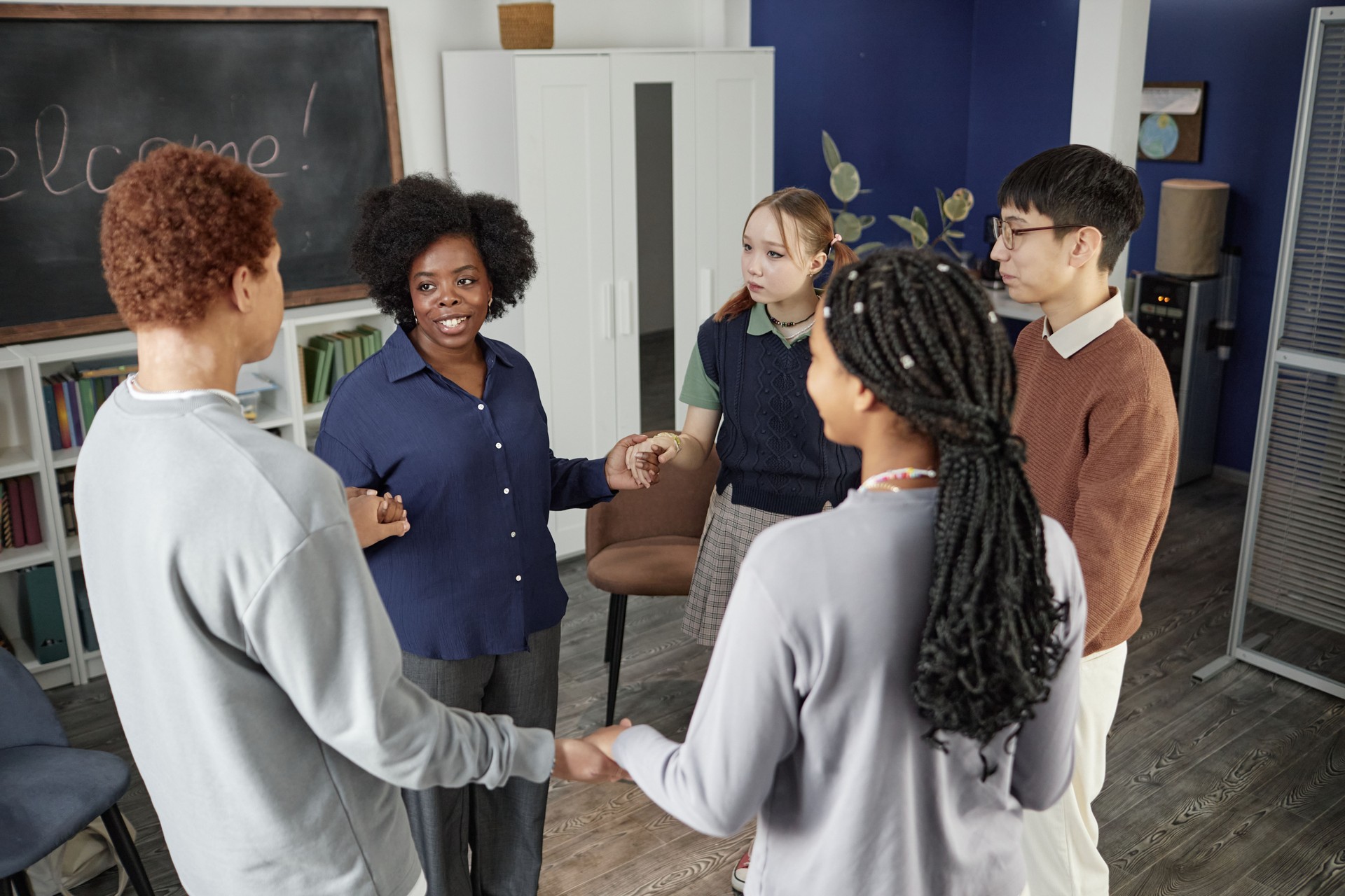 Group of Teenagers Standing in Circle Holding Hands in Group Therapy